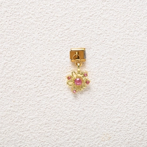 Detailed view of daisy pendant charm in gold metal with pink cubic zirconia stones