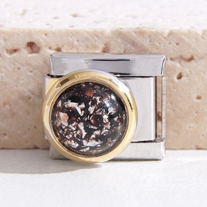 Makroaufnahme von Edelstahl Italian Charm mit ovalem goldumrandetem Glitzerstein