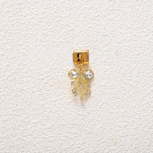 Macro detail of golden bow charm with sparkling crystals for Italian modular bracelets