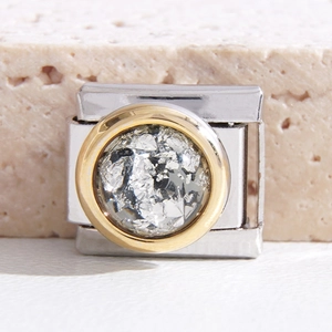 Makro-Detail des italienischen modularen Charms mit Goldrand und Silber-Glitzer-Inlay