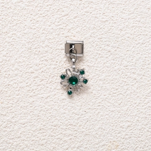Macro detail of Italian style dangle charm with sparkling emerald green crystal flower petals