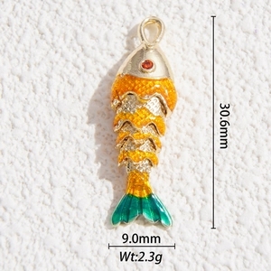 Dettaglio di un ciondolo carpa koi colorato con smalto arancione e finiture dorate