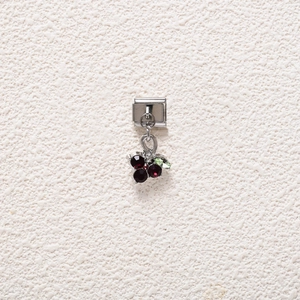 Macro shot of Italian charm link featuring a silver berry pendant with red and green crystals