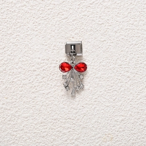 Detailed close-up of a bow-shaped charm with red stones and zircon tassels for DIY bracelets
