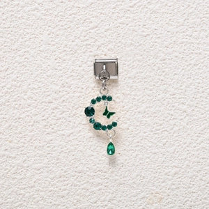 Macro view of Italian charm link featuring emerald moon, butterfly, and drop gem pendant