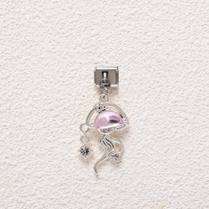 Macro detail of a jellyfish charm pendant with pink inlay and crystals for DIY bracelet