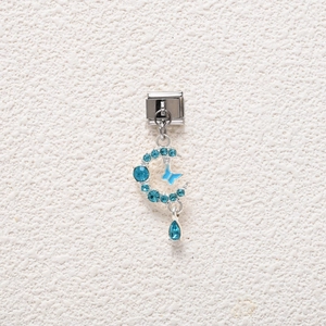 Detail of silver charm featuring a blue rhinestone crescent moon and enamel butterfly