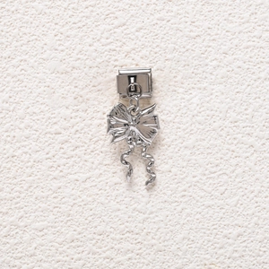 Macro detail of silver stainless steel bow pendant with modular link charm