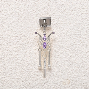 Macro shot of a silver butterfly modular link charm with purple crystals and tassels