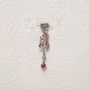 Macro detail of Italian charm bracelet link with pink crystal vine dangle pendant