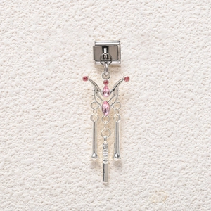 Macro detail of Italian charm with pink rhinestones and metallic tassels