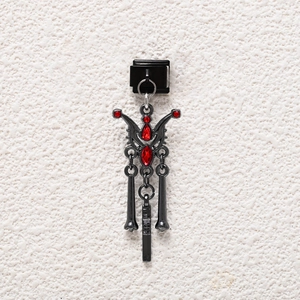 Detail of gothic style black metal link charm with red teardrop and round gemstones