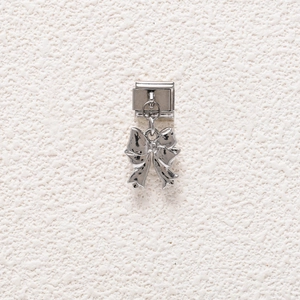 Close-up of a silver bow charm pendant for Italian modular charm bracelets