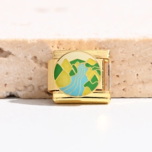 Macro detail of a gold Italian charm link with colorful enamel landscape design