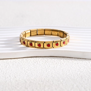 Detail of 18K gold stainless steel bracelet showing red strawberry enamel and material engraving