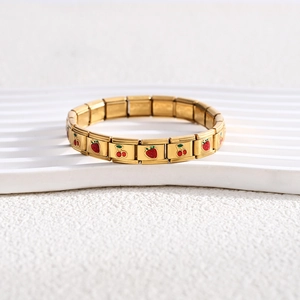 Detailed macro view of 18K gold modular charm bracelet with cherry and strawberry icons