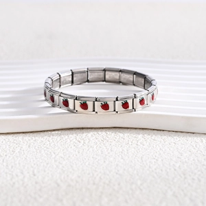 Macro shot of stainless steel modular bracelet with red enamel strawberry charms