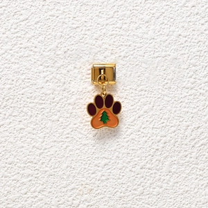 Detailed macro shot of golden dog paw charm with Christmas tree pattern for charm bracelets
