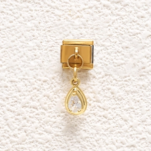 Detailed close-up of a gold-plated stainless steel charm with pear-cut cubic zirconia