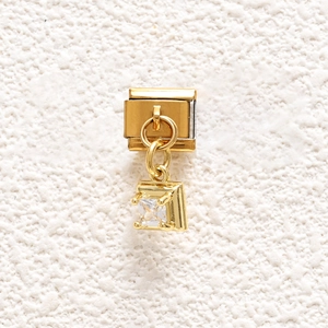 Detailed close-up of a golden Italian link charm with a square-cut clear cubic zirconia