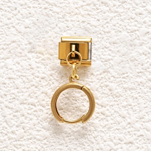 Macro shot of a polished gold stainless steel modular bracelet charm on a white background