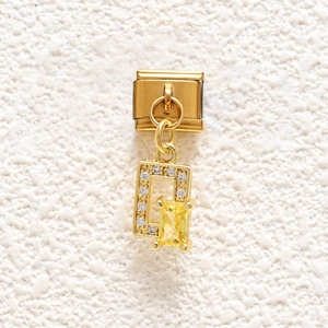 Detailed view of Italian gold charm with rectangle yellow crystal and cubic zirconia