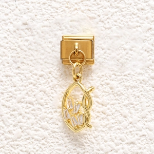Close-up of gold Italian charm link with hollow leaf pendant and white zircon stones