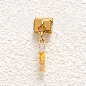Macro detail of Italian charm link with gold finish and three colored gems