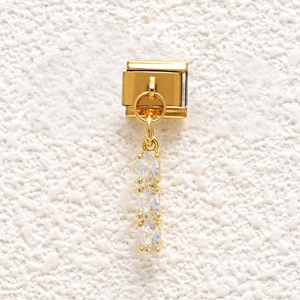 Macro shot of gold Italian charm link featuring three stacked oval cubic zirconia stones