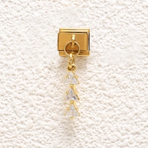Close-up of gold modular charm with three vertical triangle zircons and claw setting