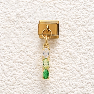Close-up of golden Italian charm link featuring three vertical white and green zircon stones