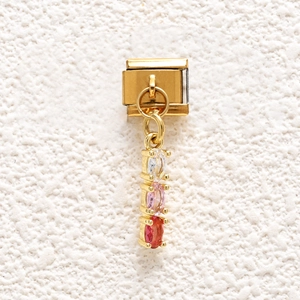 Detail of Italian modular charm link featuring three oval crystals in white, pink, and red