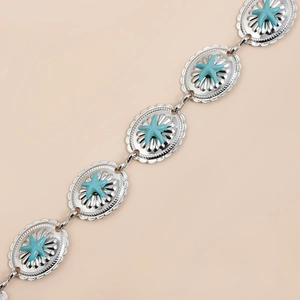 Macro detail of silver belt links featuring turquoise starfish in a bohemian style