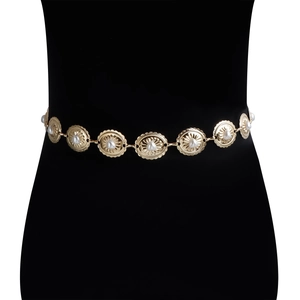 Detail of gold bohemian waist chain featuring embossed sunburst motifs and inlaid pearls