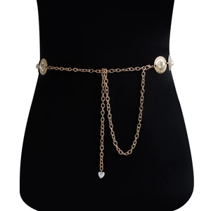 Detail of gold chain belt with heart pearl pendant and engraved pearl charms on model