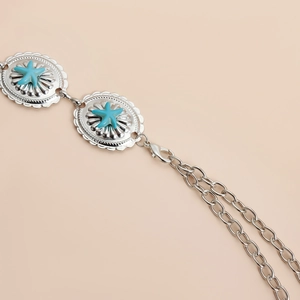 Close-up of bohemian silver chain belt featuring vintage turquoise starfish medallions