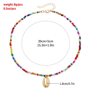 Détail du collier de perles colorées avec pendentif coquillage doré et chaîne réglable