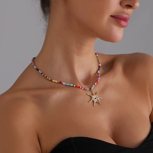 Collier bohème en perles colorées avec pendentif étoile dorée porté par un mannequin