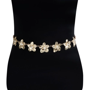 Détail de la chaîne de taille fleurie dorée avec perles blanches sur un mannequin noir élégant
