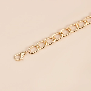 Detailed macro view of a shiny gold heart pendant link chain with a lobster clasp