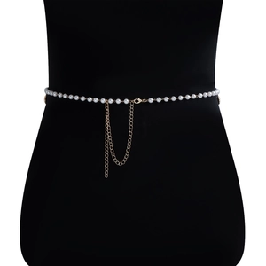 Detail of elegant pearl body chain featuring white pearls and golden lobster clasp closure