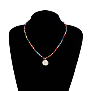 Détail d'un collier de perles bohème coloré avec pendentif coquillage et perle