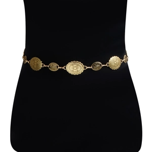 Close-up of vintage gold waist chain with embossed ethnic totems on a black mannequin