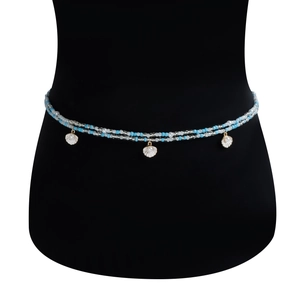 Detail view of double-layered beaded body chain with shell pendants and golden pearl edges