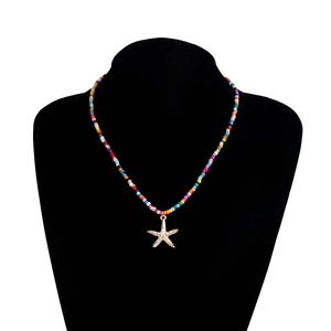 Vue détaillée du collier bohème en perles colorées avec pendentif étoile de mer doré