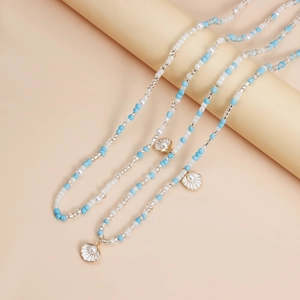 Detailed macro of double-layer beaded body chain with blue pearls and seashell charms