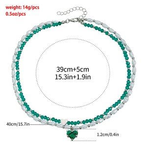 Détail du collier double rang avec cristal de cœur vert et perles blanches