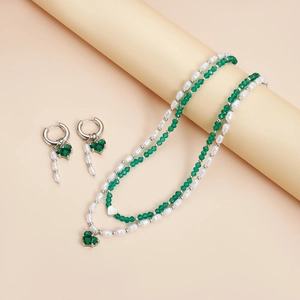 Vue détaillée d'une parure de luxe avec cristaux verts et perles blanches de culture