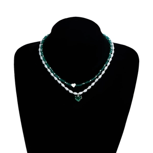 Détail du collier double rang avec perles de cristal vert émeraude et pendentif cœur