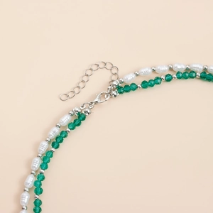 Détail d'un collier double rang avec perles baroques et perles de cristal vertes